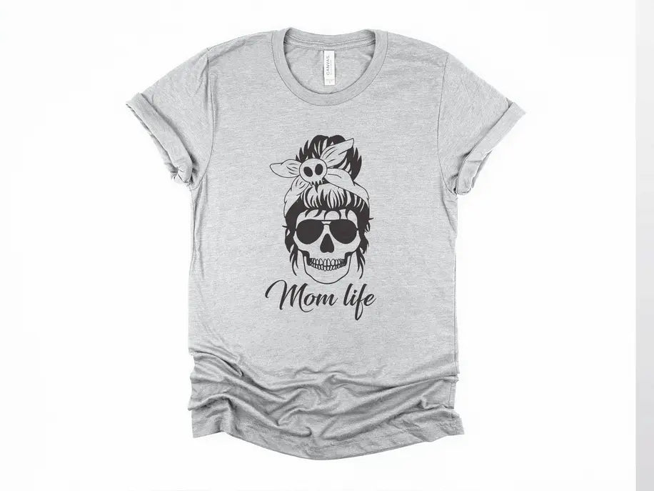 Gray t-shirt featuring a stylish skull design with a bow and "Mom life" text in black. Casual, trendy women's wear.