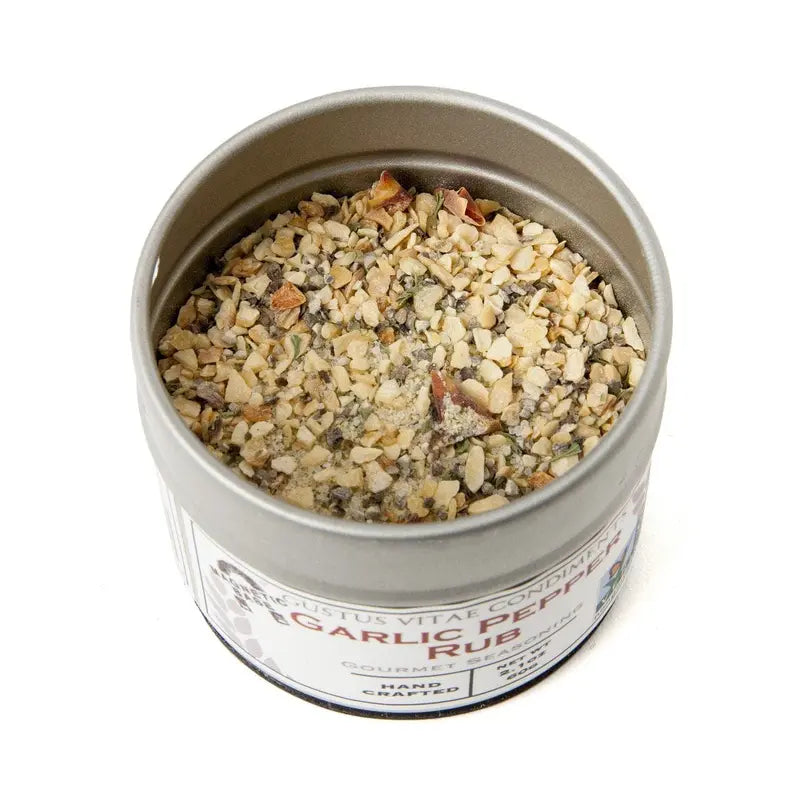 Garlic pepper rub in a silver tin, featuring coarse dried garlic, herbs, and spices for gourmet cooking.