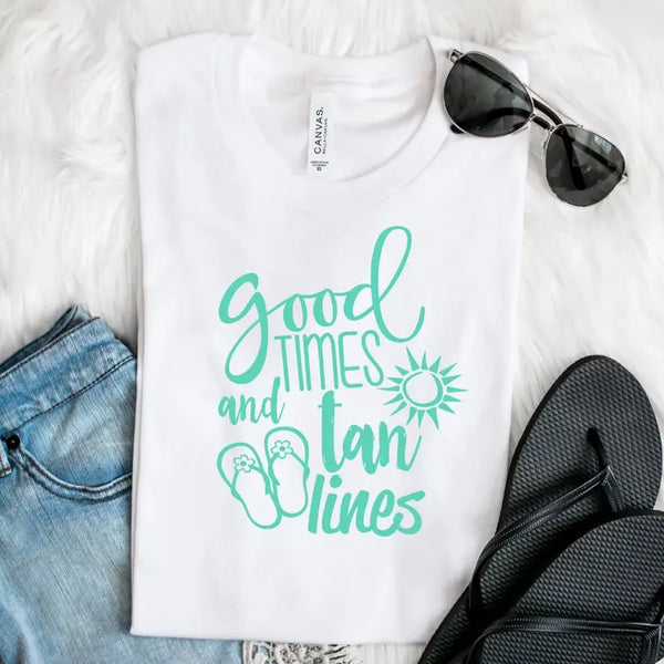 Mint green graphic tee with "Good Times and Tan Lines," paired with black flip-flops and sunglasses on a plush white background.