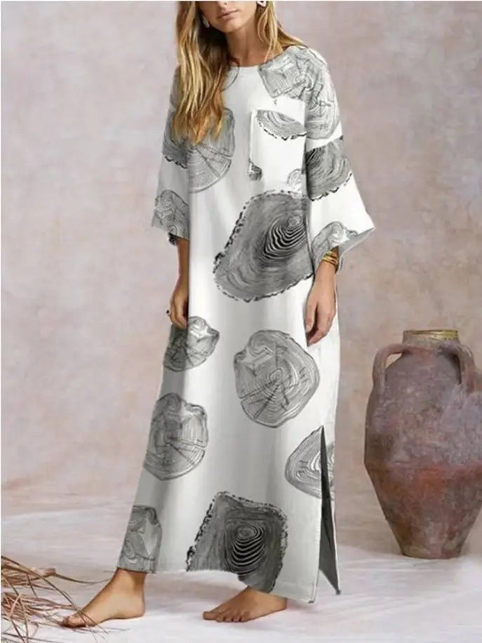 Women's long grey and white printed maxi dress with oversized sleeves and side slit, made from lightweight fabric.