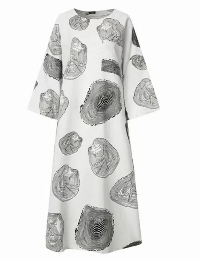 White maxi dress with black abstract rock prints and loose sleeves, perfect for casual summer wear.