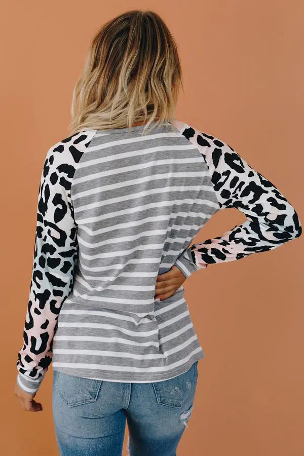 Grey striped long sleeve shirt with pink and black leopard print sleeves, casual style for women.