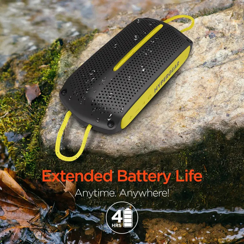 Black and yellow waterproof portable speaker with extended battery life, set against a natural outdoor backdrop.