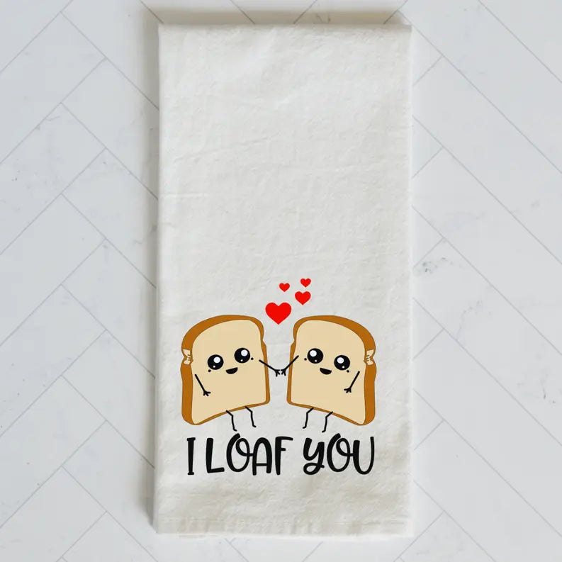 Cute white cotton towel with cartoon loaf bread characters and "I Loaf You" text, perfect for kitchen decor.