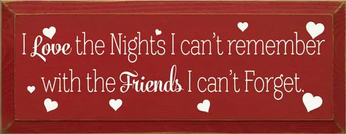 Rustic red wooden sign with white text: "I Love the Nights I can't remember with the Friends I can't Forget."