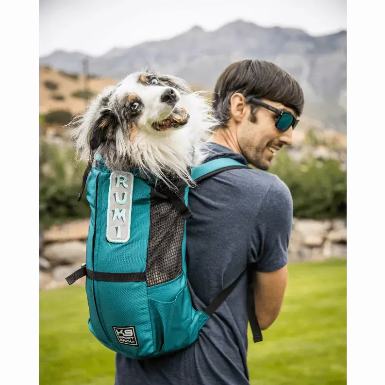 Teal dog carrier backpack with mesh panels, comfortable fit, and adjustable straps, perfect for outdoor adventures.