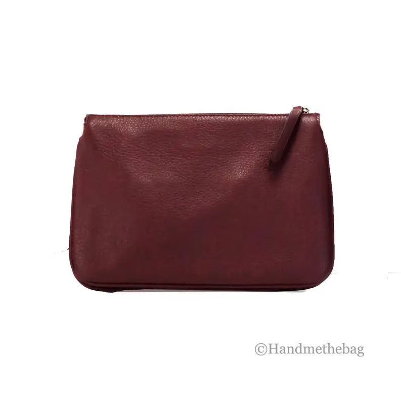 Burgundy leather zip clutch bag, featuring a sleek minimalist design and textured finish. Perfect for everyday use.