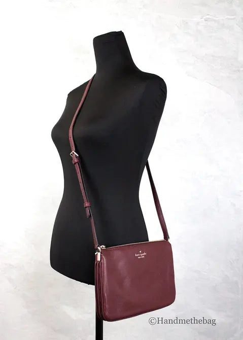 Burgundy leather crossbody bag with adjustable strap and gold-tone hardware, perfect for stylish everyday use.