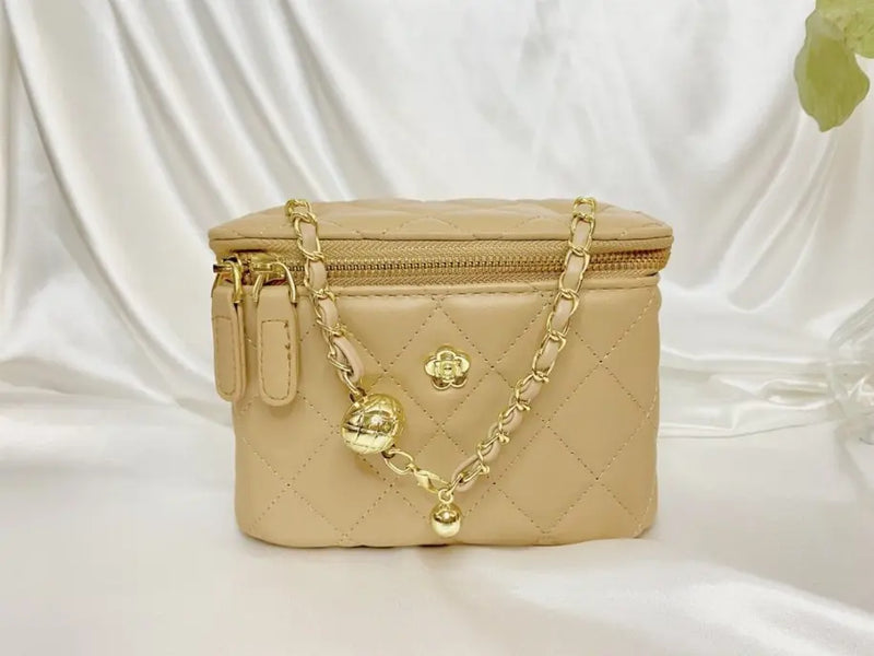 Beige quilted leather cosmetic bag with gold chain strap, featuring a gold charm for a chic, stylish look.