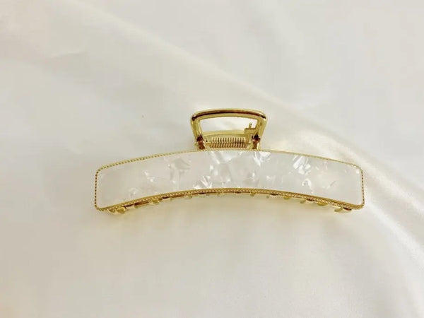 Gold-accented hair clip with a white marbled design, perfect for elegant hairstyles.