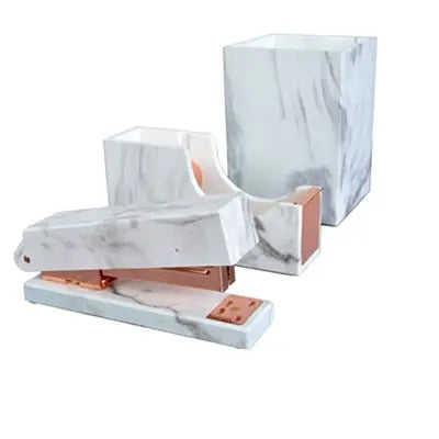 Elegant white marble office supplies set with rose gold accents, including a stapler, tape dispenser, and pencil holder.