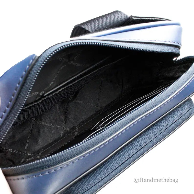 Navy blue leather crossbody bag with zip closure, featuring multiple interior compartments and a sleek, modern style.