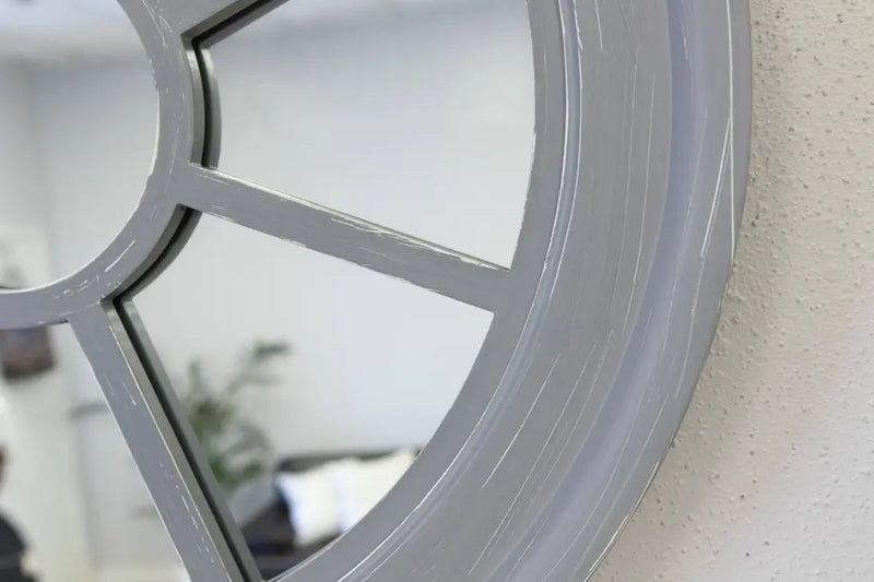 Stylish round gray wall mirror with a vintage windowpane design, perfect for home decor.