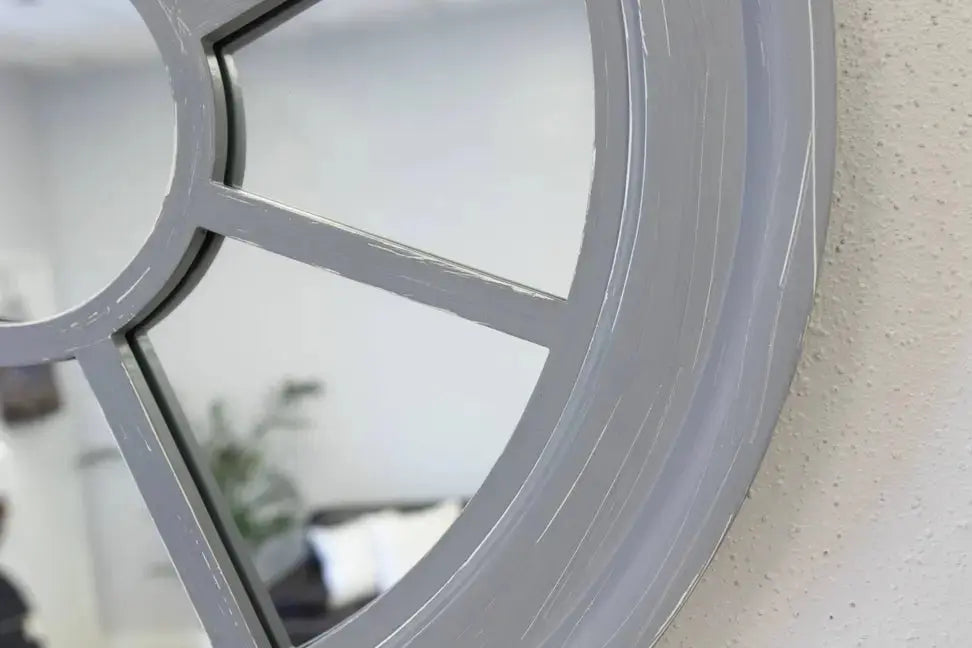 Round gray framed mirror with a modern, window-pane design, ideal for stylish home decor.