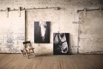 Black and white horse canvas prints in a rustic setting with wood flooring and industrial wall decor.