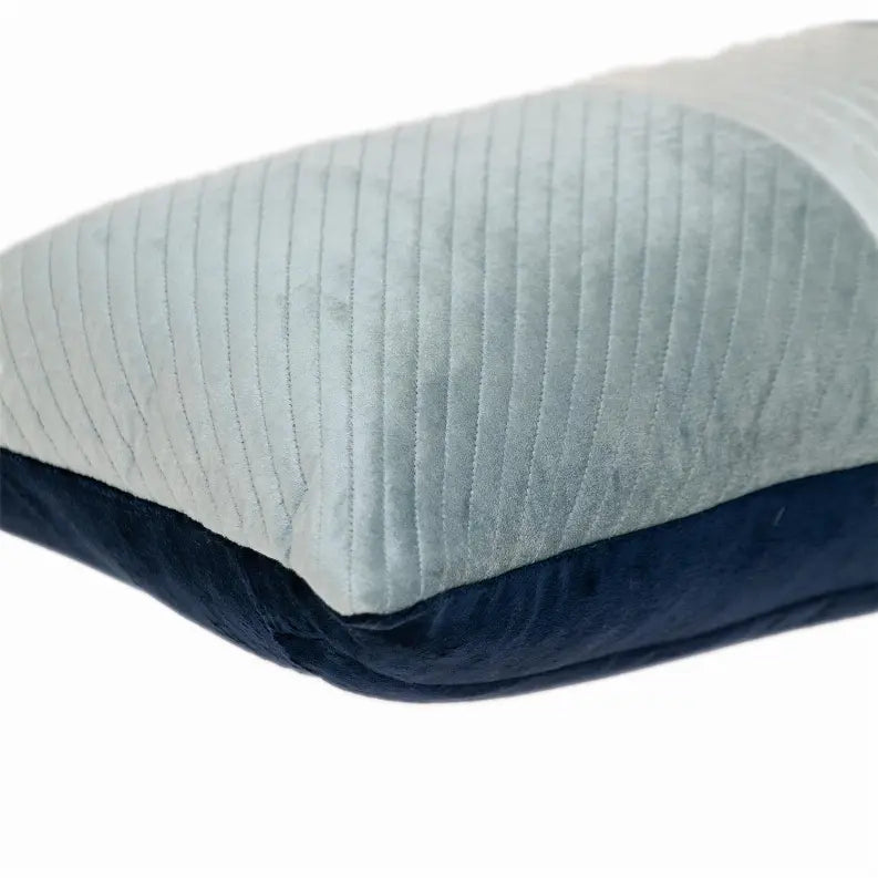 Soft teal and navy velvet pillow with ribbed texture, perfect for modern home decor.