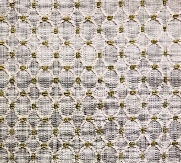 Textured beige fabric with green oval patterns, perfect for upholstery and home decor projects.