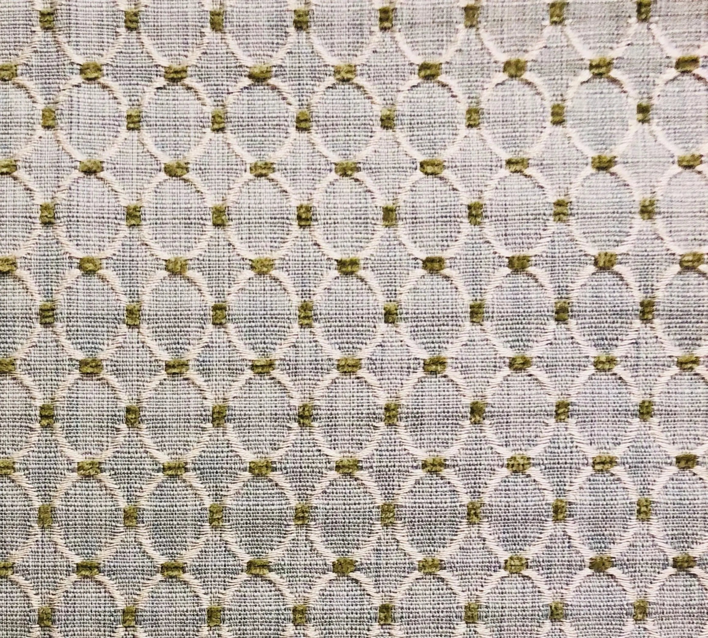 Textured light beige fabric with oval patterns in muted olive green, ideal for upholstery or curtains.