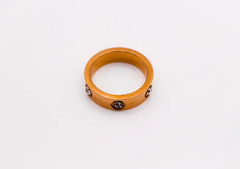 Gold-tone metal ring with three sparkling brown gemstones, perfect for elegant jewelry collections.