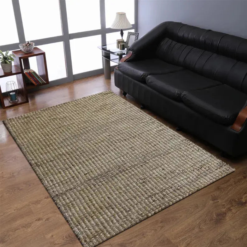 Natural jute area rug in beige and tan, perfect for modern living room decor, complementing black leather sofa.