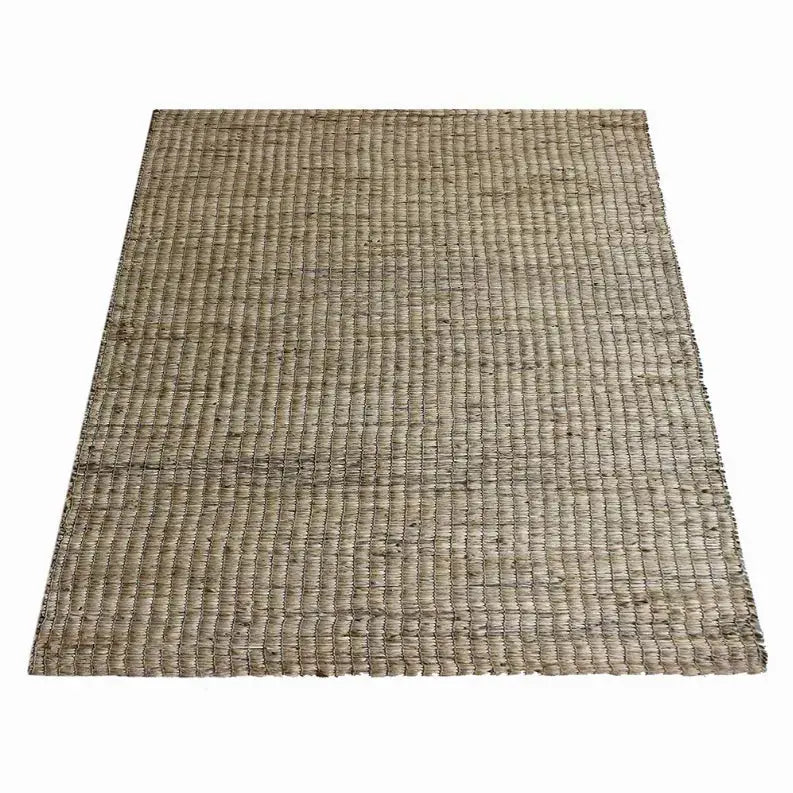 Natural jute area rug in beige, woven texture, perfect for bohemian or rustic home decor.