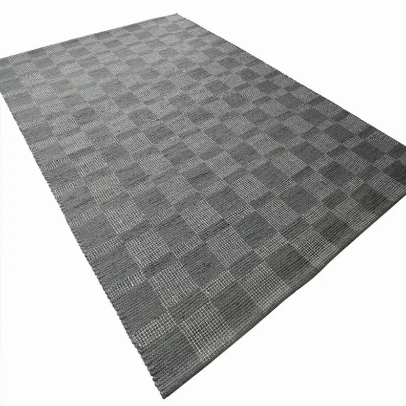Gray checkered area rug, made from durable synthetic fibers, perfect for contemporary home decor.