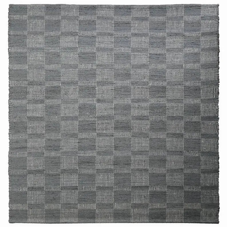 Gray woven checkered rug made from durable materials, perfect for modern and minimalist home decor.