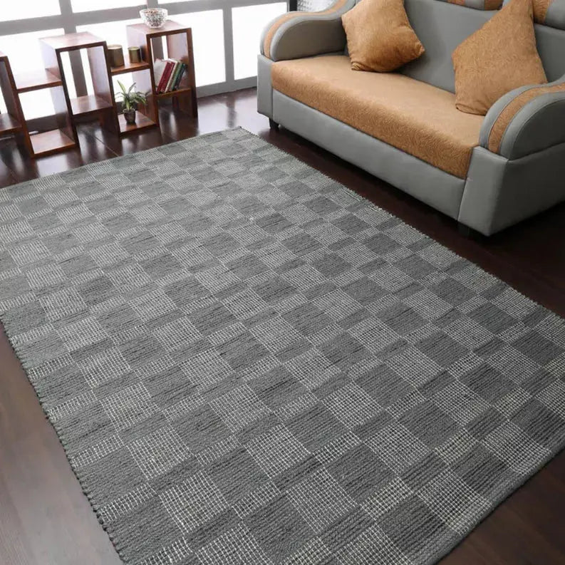 Gray checkered woven area rug, soft texture, perfect for modern living room decor.