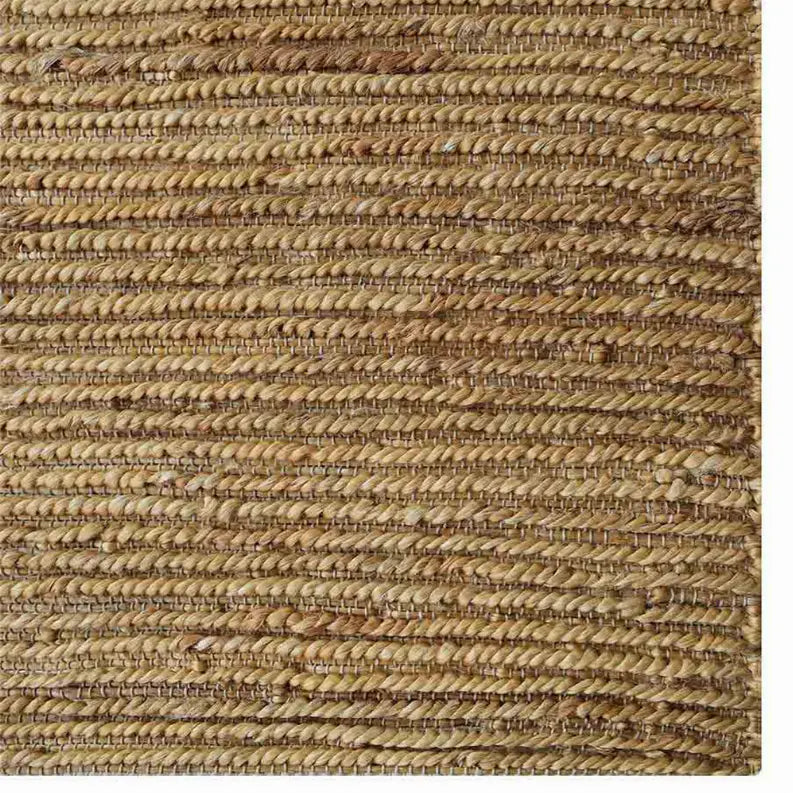 Natural jute area rug in warm beige tones, featuring a braided texture and a rustic style, perfect for boho decor.