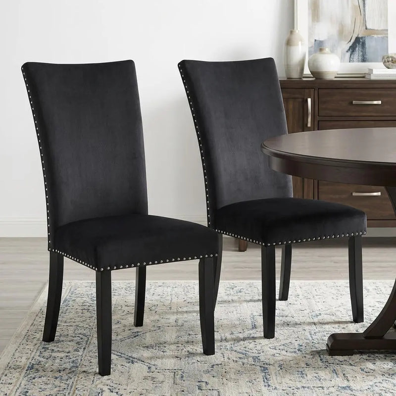 Stylish black suede dining chairs with nailhead trim and dark wooden legs, perfect for modern interiors.