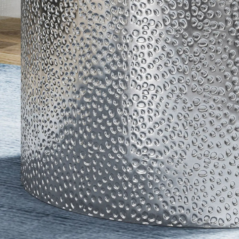 Silver hammered metal drum accent table with textured surface, perfect for modern decor.