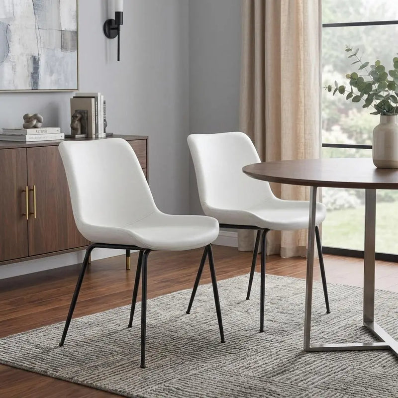Modern white faux leather dining chairs with black metal legs, perfect for contemporary dining spaces.