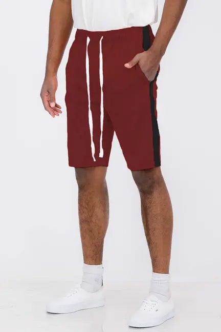Men's burgundy athletic shorts with black side stripes and white drawstrings, made from lightweight cotton blend fabric.