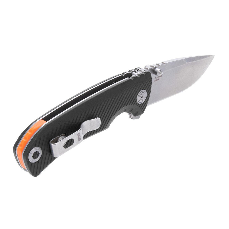 Black folding pocket knife with stainless blade, orange trim, and pocket clip