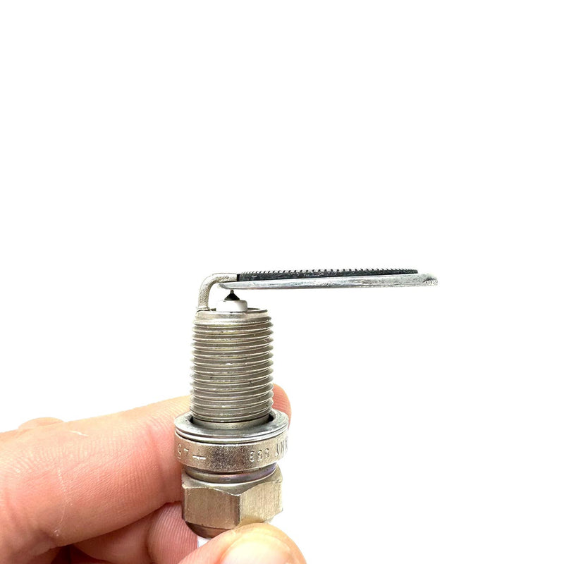 Spark plug gapper tool with threaded metal tip and hex base, held by fingers