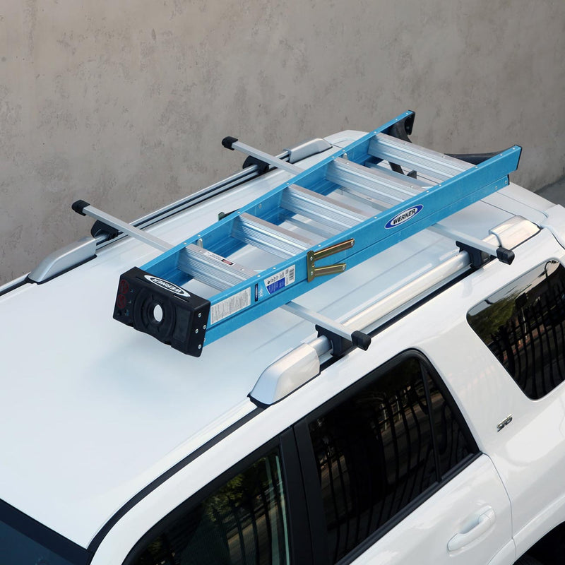 Roof rack cross bars with adjustable black clamps mounted on a blue platform