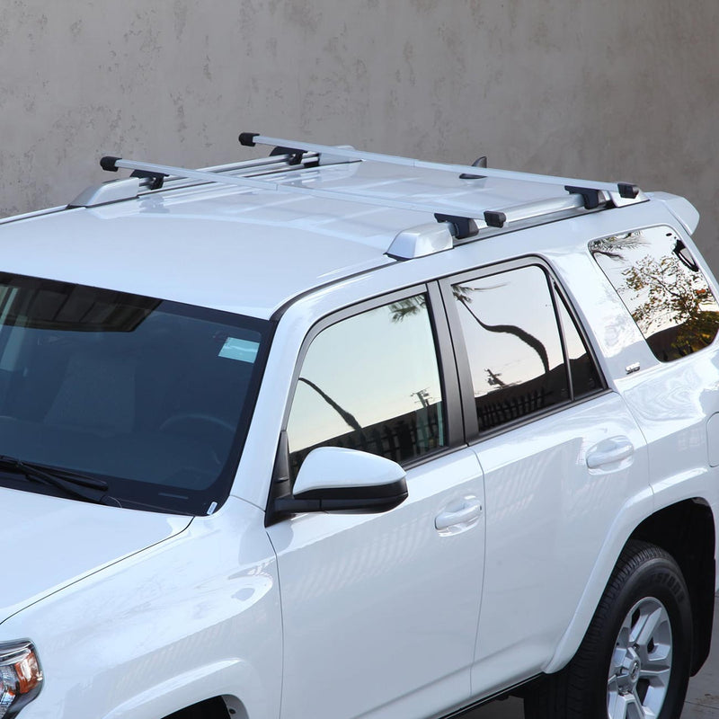 Roof cross bars mounted on a white SUV roof with black feet and silver rails