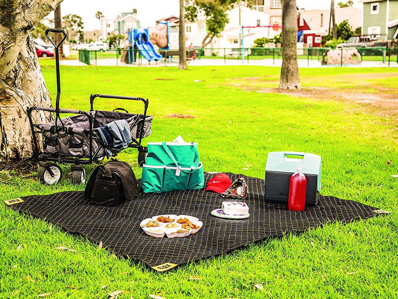 Padded utility moving blanket, black quilted grid picnic-style base on grass