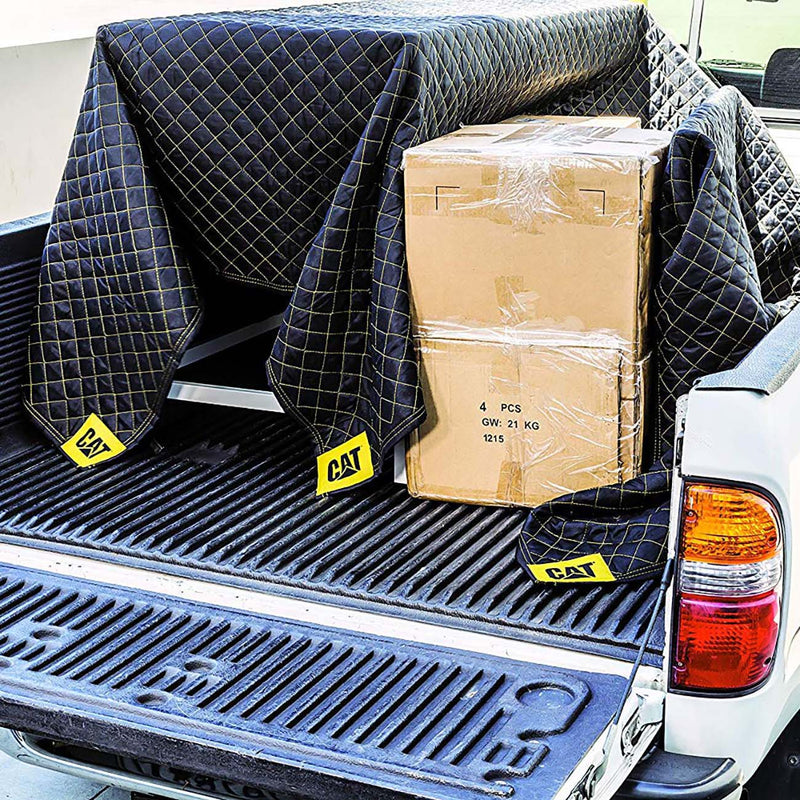 Padded utility moving blanket in truck bed, dark blue quilted grid with CAT corner labels