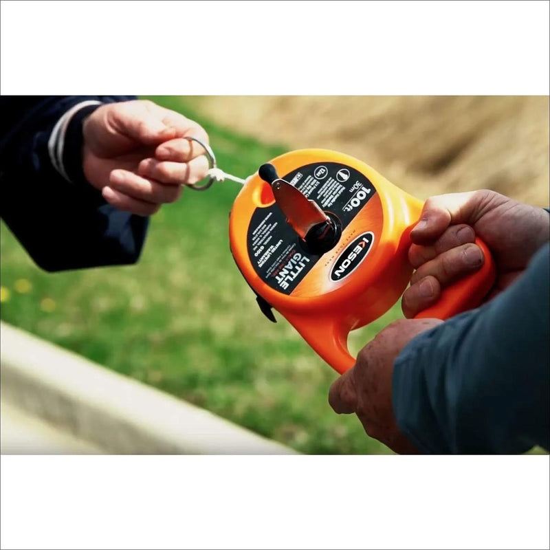 Orange chalk line reel with hand crank, line spool window, and metal tip