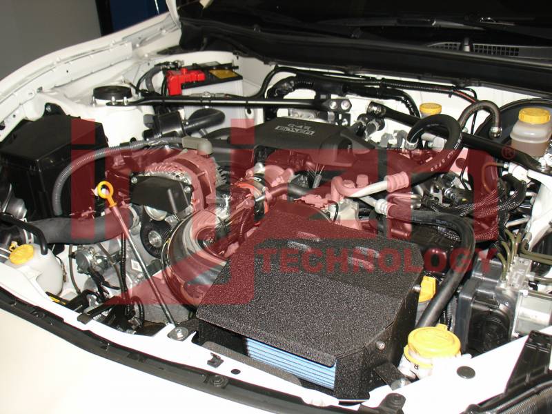 Engine bay view of black short ram intake box and tubing with blue filter