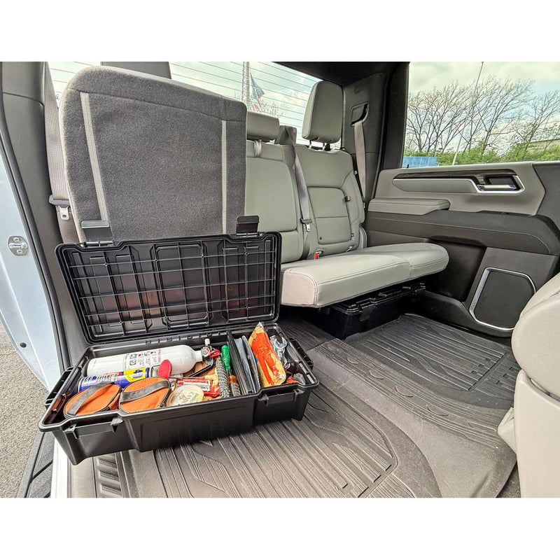 Black grid-top organizer crate open on truck cargo floor beside front seat