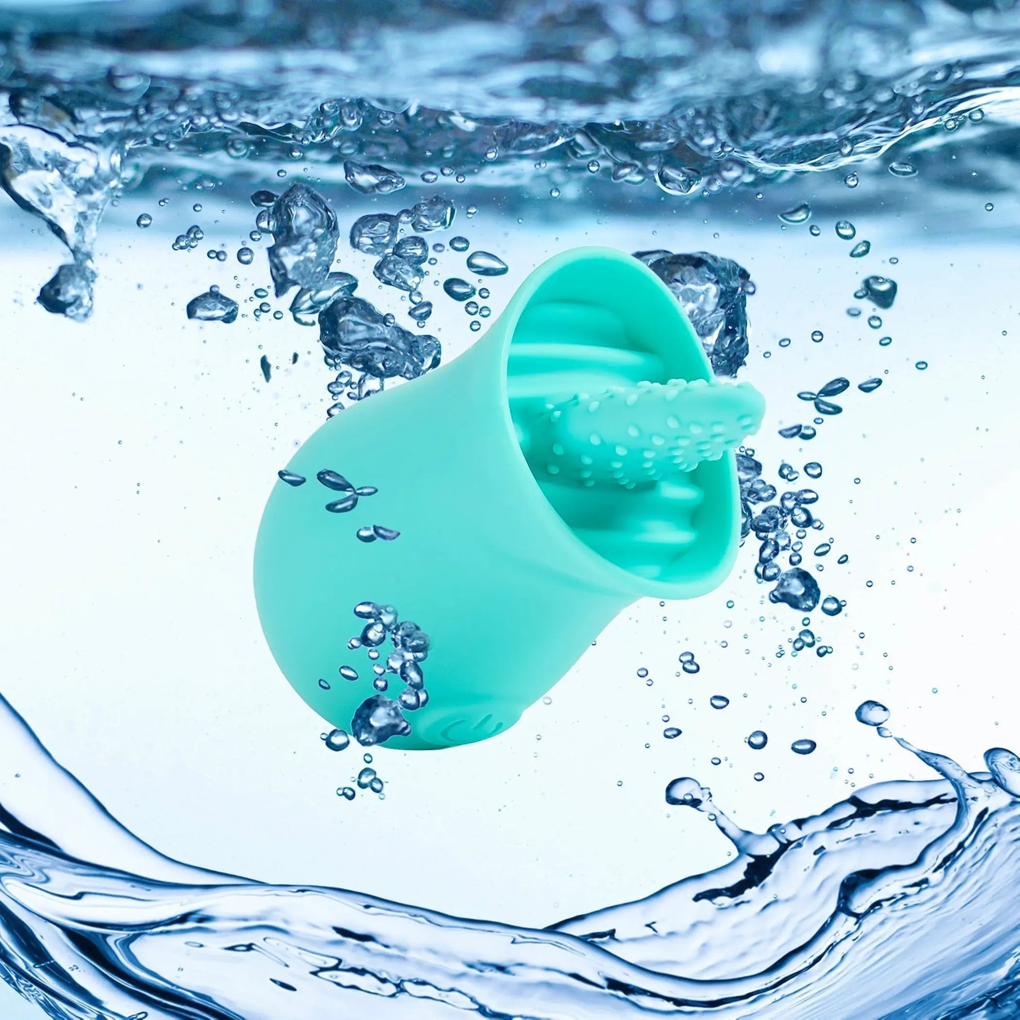 Turquoise silicone facial cleansing brush floating in water, featuring textured soft bristles for deep cleaning.