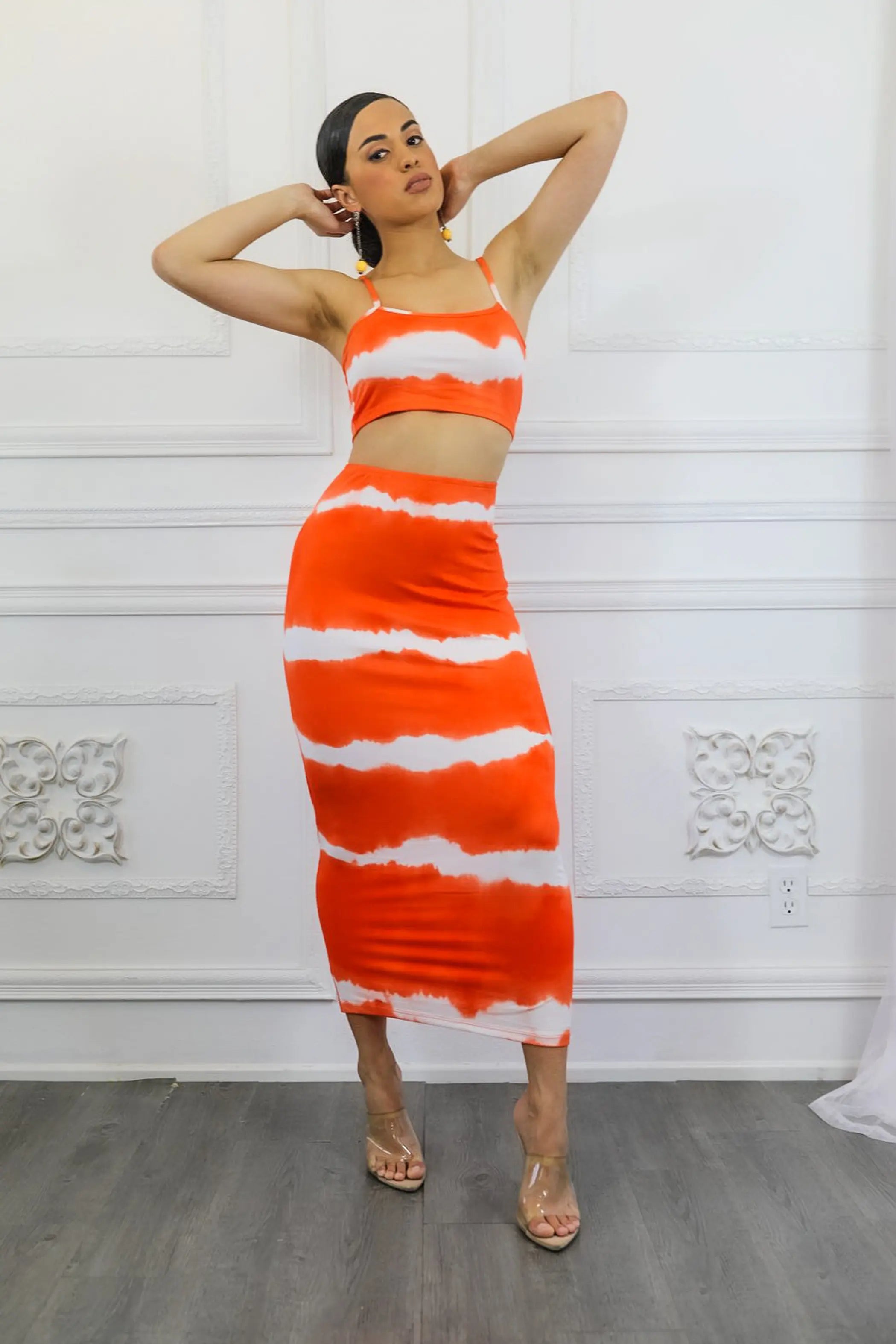 Orange and white tie-dye two-piece set featuring a cropped top and midi skirt, perfect for summer outings.