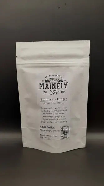 Turmeric ginger tea blend in a white resealable pouch, organic and low calorie, featuring earthy spices and vibrant flavors.