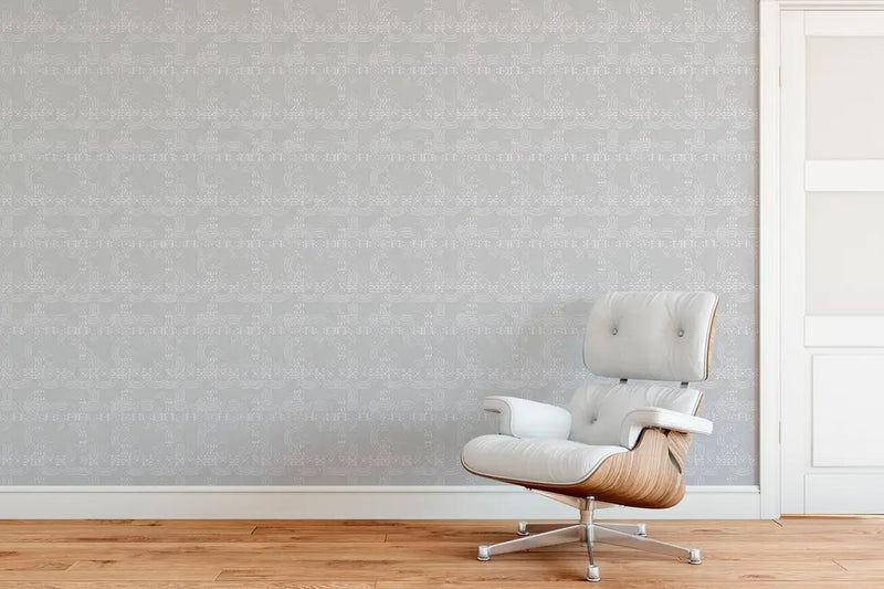 Modern grey patterned wallpaper paired with a white leather and wood accent chair in a stylish interior setting.