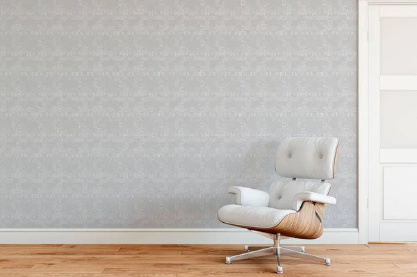 Modern white leather chair with wood accents against a textured light gray patterned wall in a stylish interior setting.