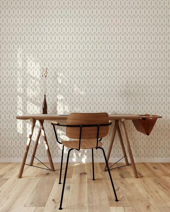 Modern wooden desk with light oak finish, black metal legs, paired with a stylish black wire chair against a patterned wallpaper.