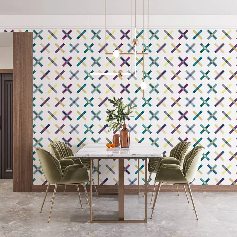 Modern dining room with a marble table, green velvet chairs, and a colorful crossed pattern wallpaper in purple and teal.