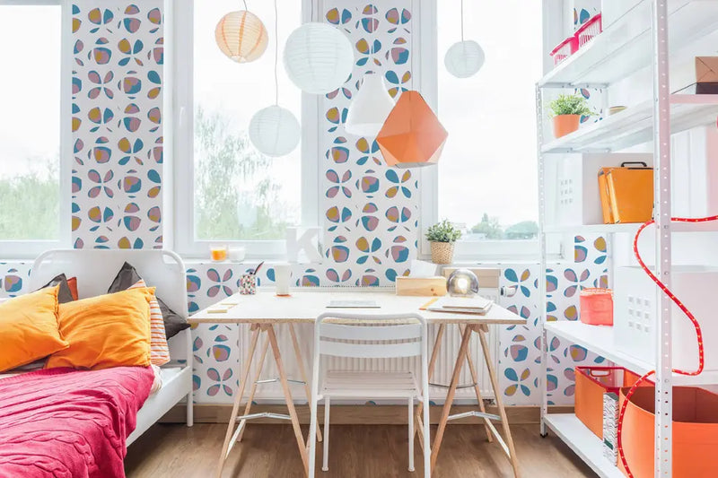 Brightly colored floral wallpaper in a modern workspace with an orange sofa, white desk, and stylish decor accents.